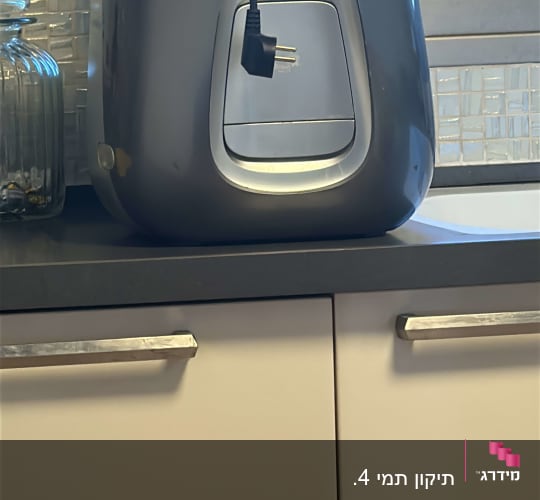 מכשיר חשמלי על משטח מטבח ליד חלון